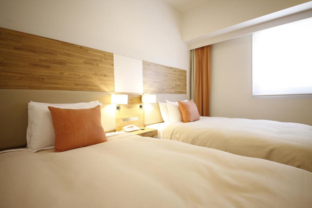 Postel nebo postele na pokoji v ubytování Sotetsu Fresa Inn Nagano-Zenkojiguchi