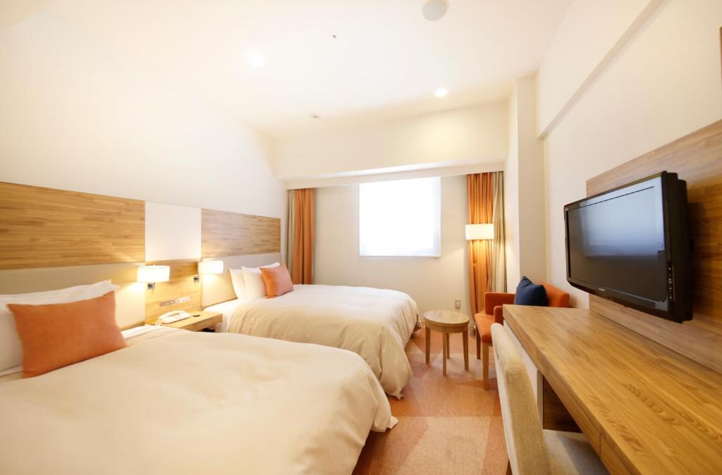 Postel nebo postele na pokoji v ubytování Sotetsu Fresa Inn Nagano-Zenkojiguchi