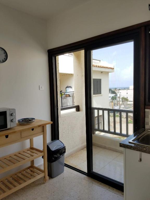 a kitchen with a sliding glass door to a balcony at Kings Avenue - Natalia's Apt in Paphos