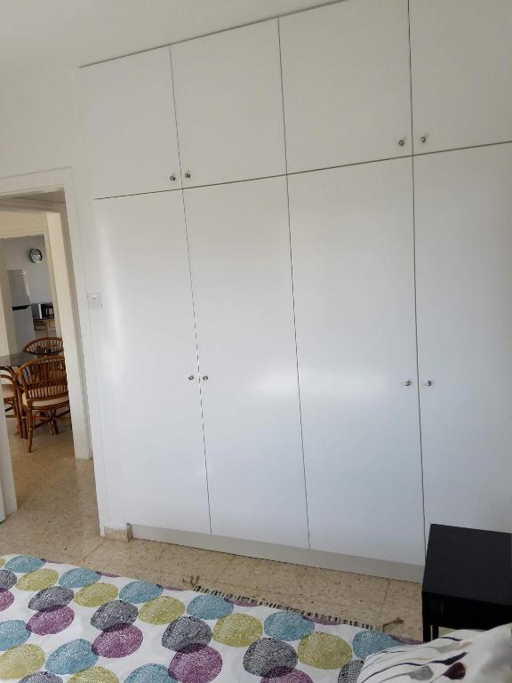 a bedroom with white cabinets and a rug at Kings Avenue - Natalia's Apt in Paphos