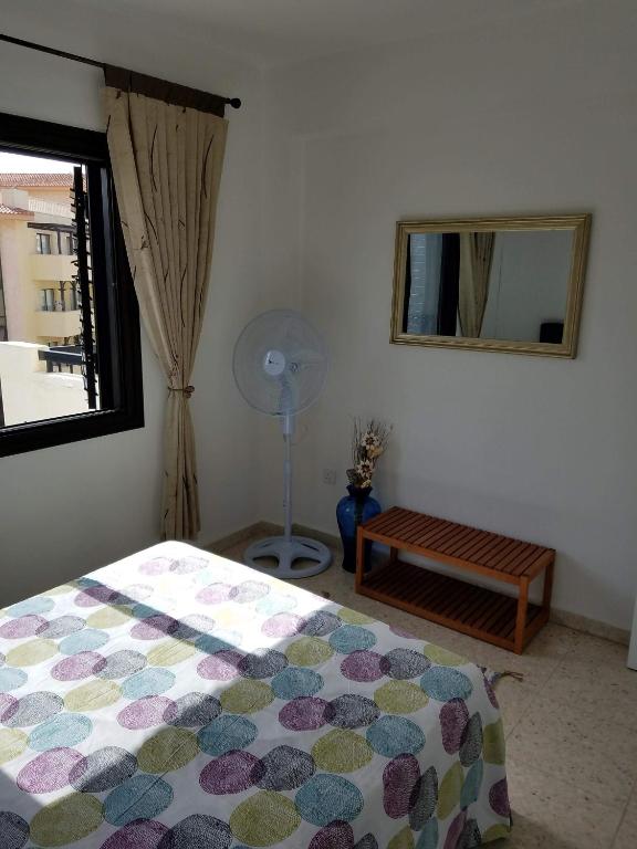 a bedroom with a bed and a window and a fan at Kings Avenue - Natalia's Apt in Paphos