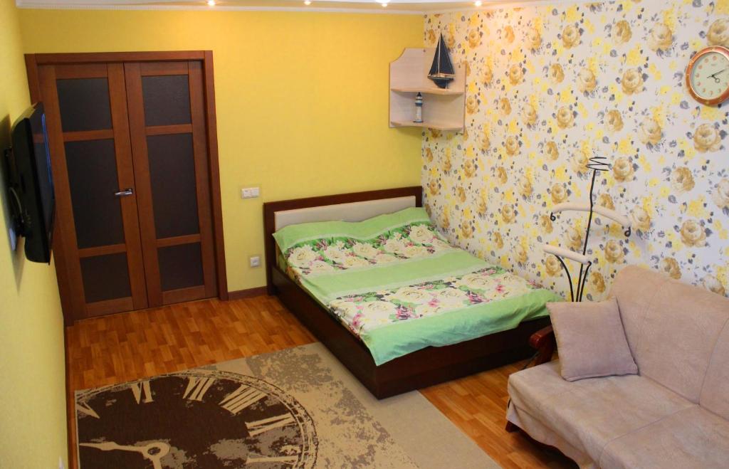 a small bedroom with a bed and a couch at Svetlana's Apartments, Center of Sumy in Sumy