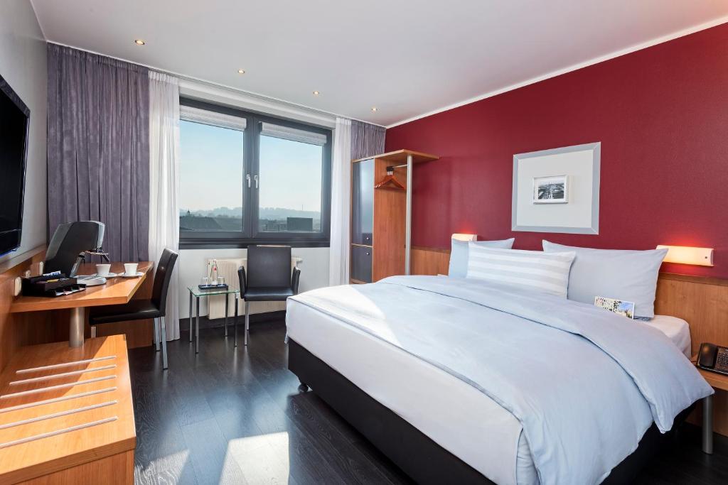 ein Hotelzimmer mit einem Bett, einem Schreibtisch und einem Computer in der Unterkunft Hotel Wolfsburg Centrum, Affiliated by Meliá in Wolfsburg