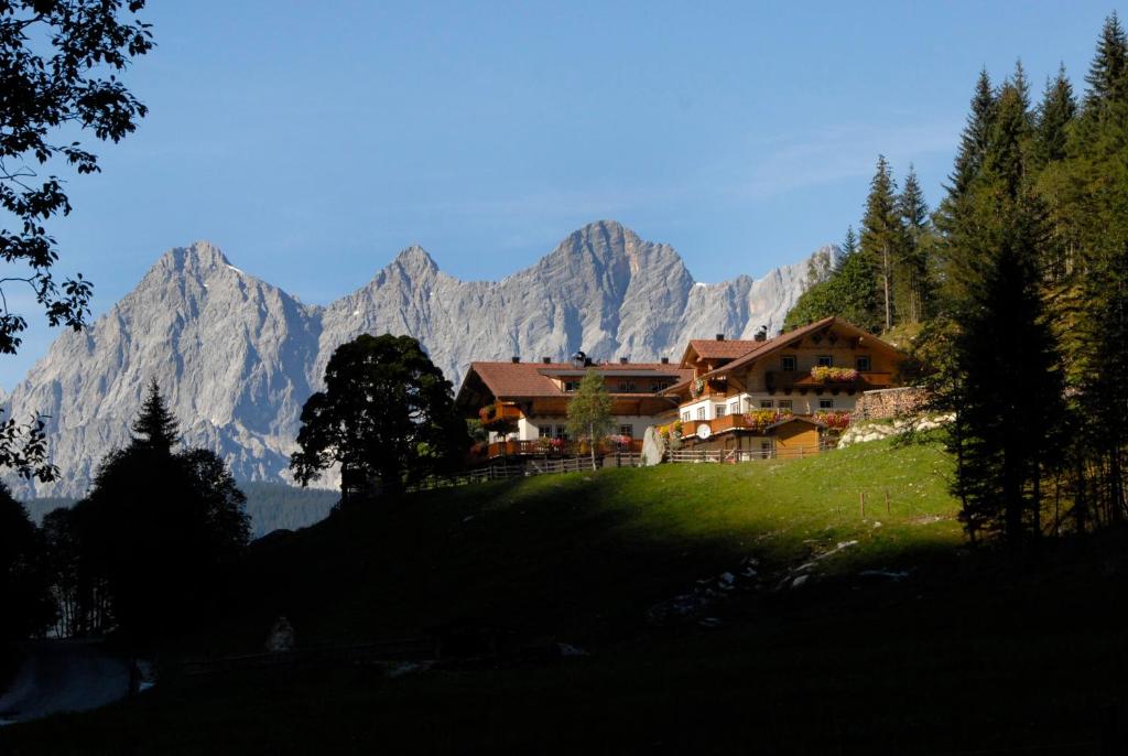 a house on a hill with mountains in the background at Strickhof in Schladming