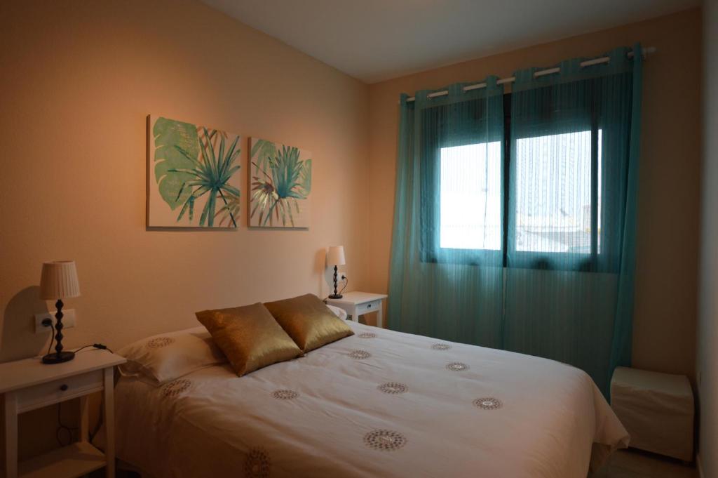 トレモリノスにあるApartamento Torremolinos centroのベッドルーム1室(白いベッド1台、窓、ベッドサイド付)