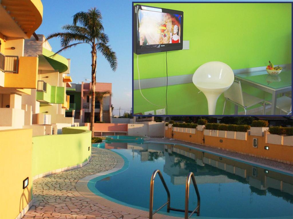 einen Pool mit einem TV auf dem Dach eines Gebäudes in der Unterkunft Con PISCINA e GARAGE a 300 m da spiaggia e centro in Torre dell'Orso