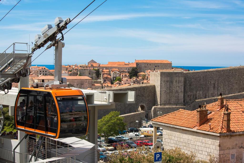 an orange cable car going over a city at Rooms Biba in Dubrovnik