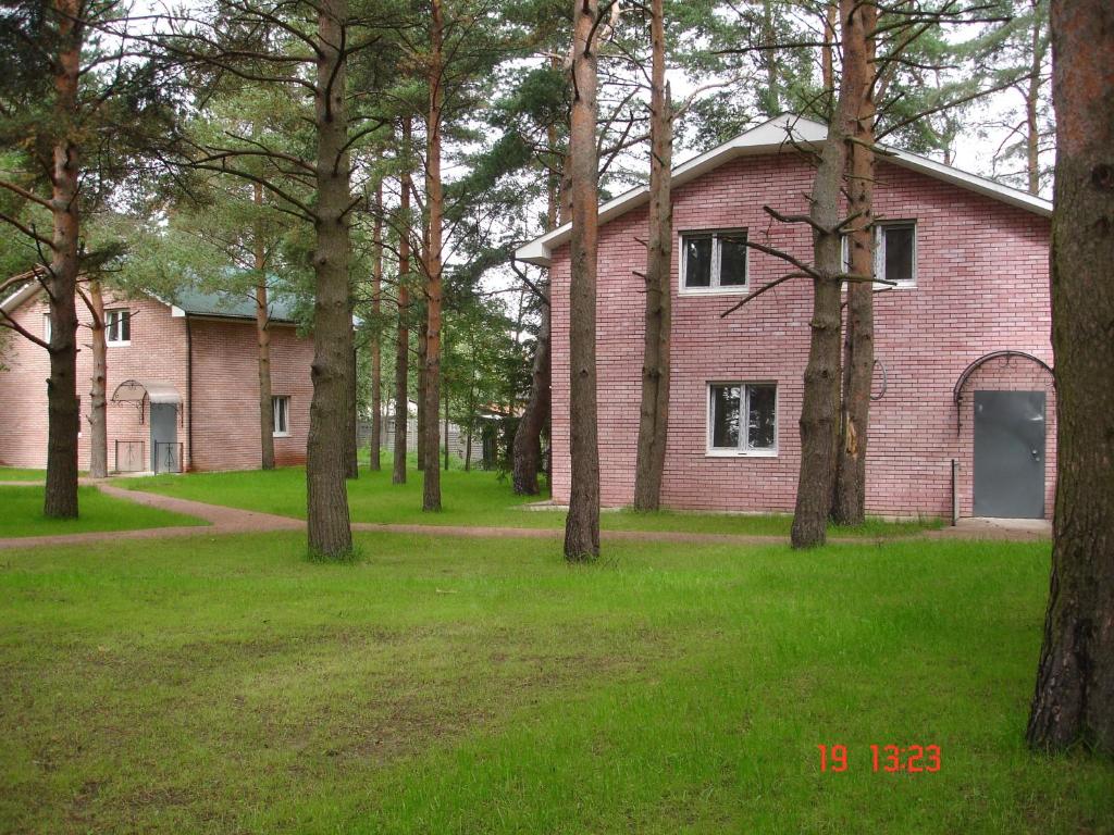 フセヴォロシュスクにあるKarinaの目の前に木々が植えられた古いレンガ造りの家
