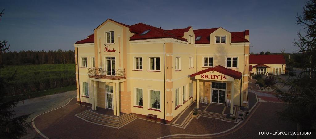 a large yellow building with a hotel sign on it at Hotel Arkada in Rawa Mazowiecka