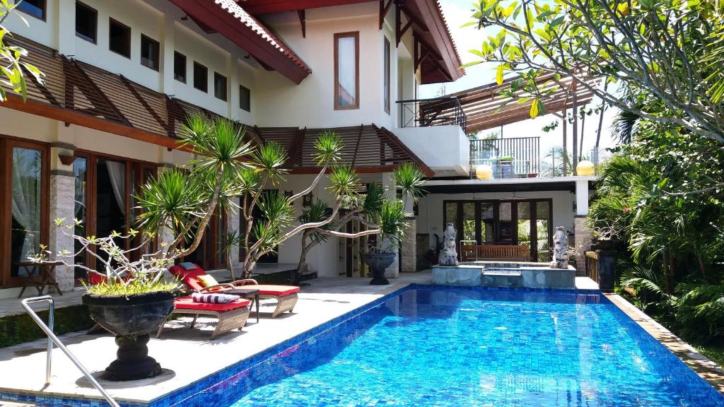 a swimming pool in front of a house at Unique spacious luxury villa in Jimbaran