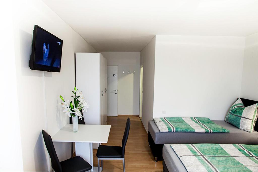 a room with two beds and a table and a tv at Das Quartier in Weitendorf