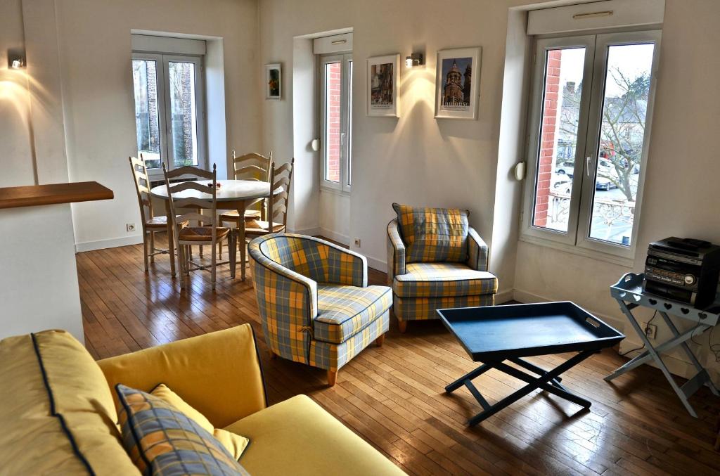 een woonkamer met een bank, stoelen en een tafel bij Papyrus Saint-Pierre in Mordelles