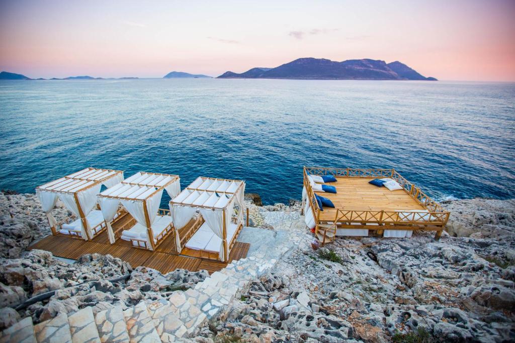 a view of the ocean with a deck and chairs at Lycia Hotel in Kaş