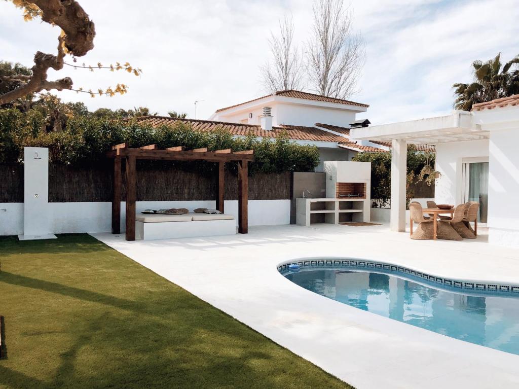 un patio trasero con piscina y una casa en Villa Fernweh - Delta de l'Ebre, en Riumar