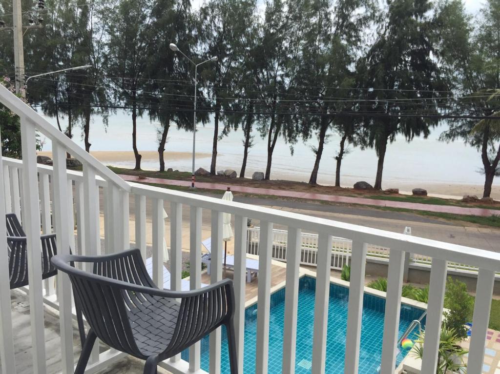 a balcony with a chair and a swimming pool at BC Summer Beach in Pran Buri