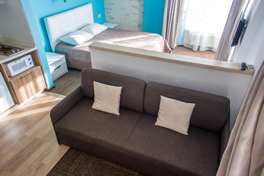 a living room with a couch and a bed at Hotel Cambridge in Izhevsk