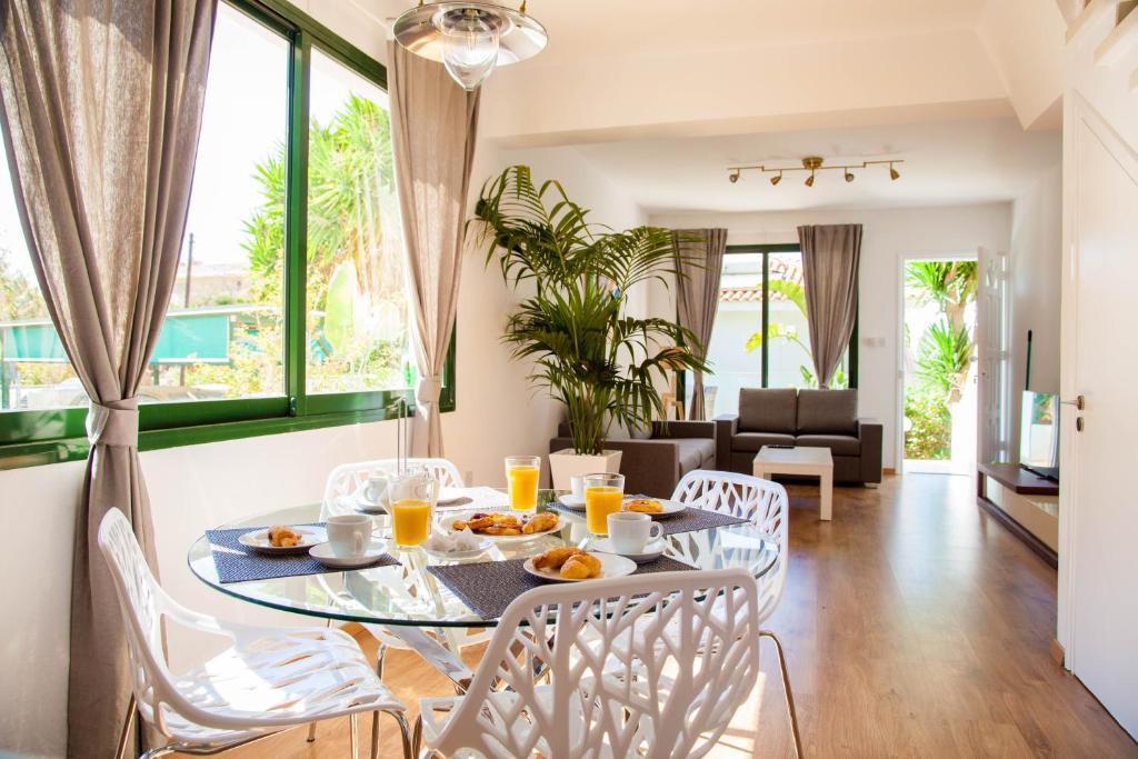a dining room and living room with a table and chairs at Julipapas Gardens in Paphos
