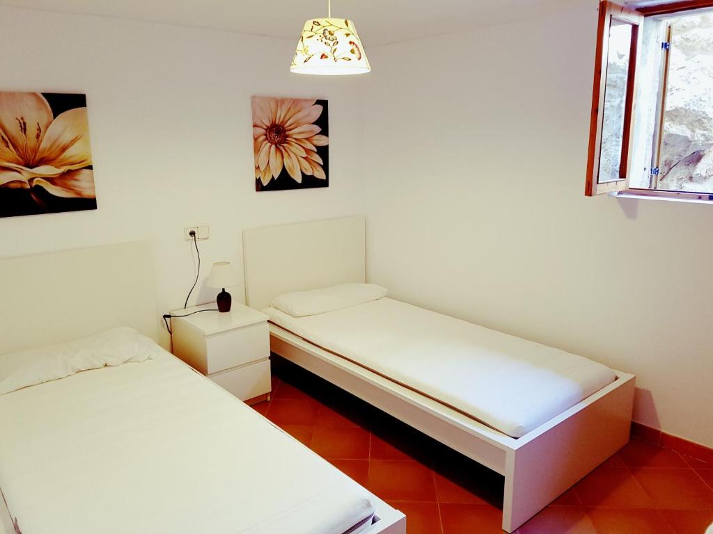 ポリェンサにあるVilla townhouse Calvarioのベッド2台と窓が備わる客室です。