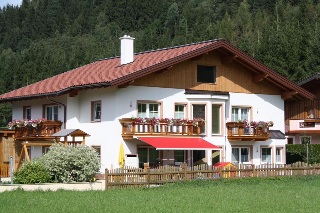 a house with flowers on the balconies of it at Alpenjuwel Appartements in Flachau