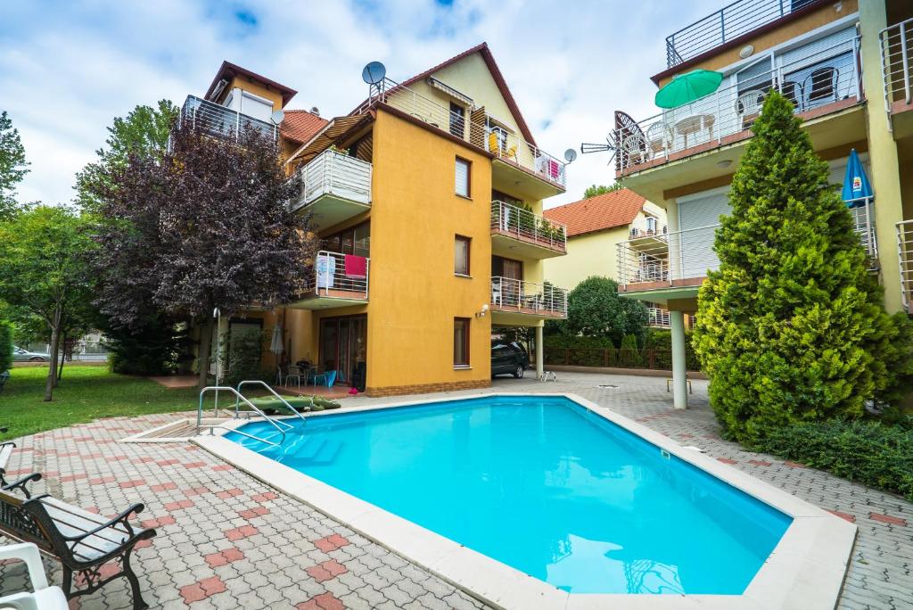 a swimming pool in front of a house at Lilly in Siófok