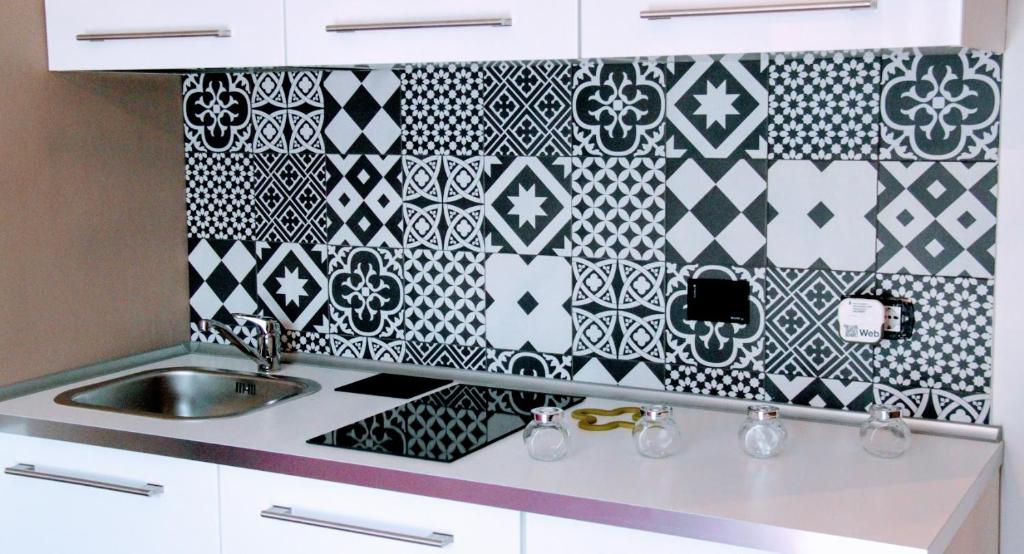 a kitchen with black and white tile on the wall at yHome | Gulli's Palace in Turin