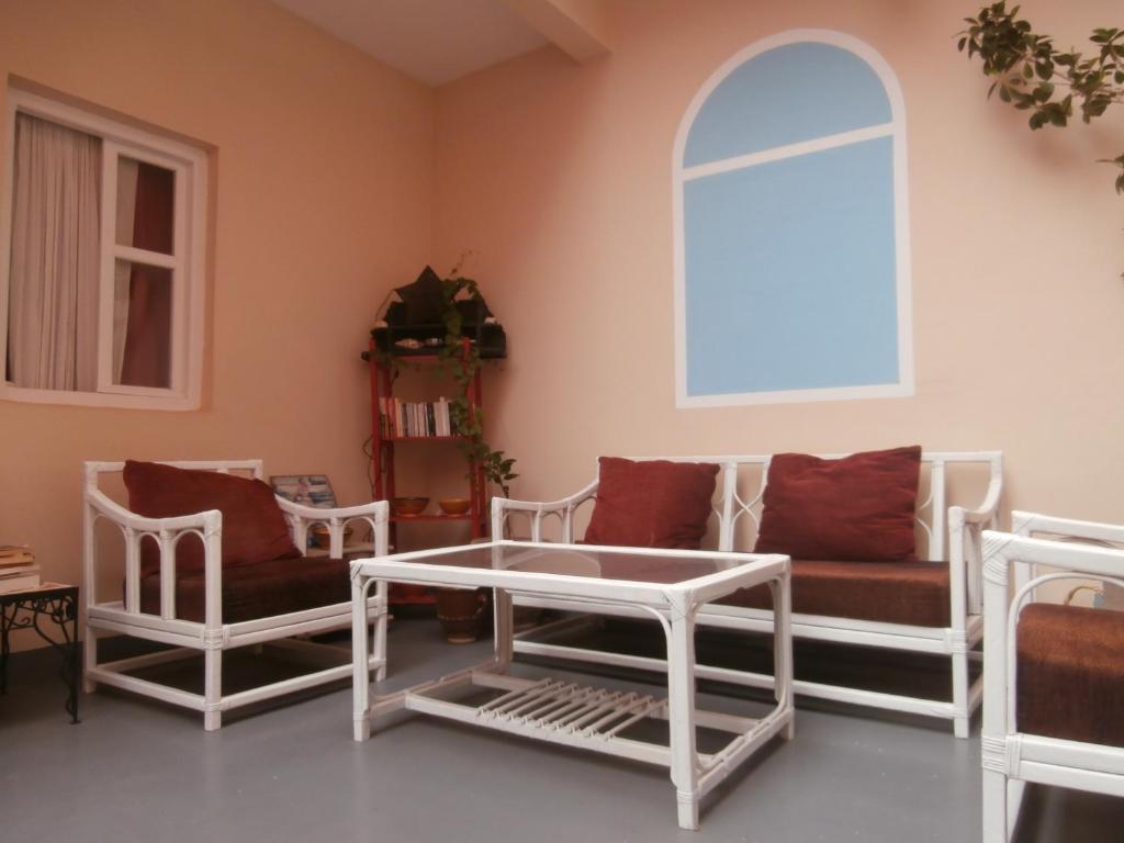 a living room with white furniture and a window at Maison Xanadu in Sidi Ifni