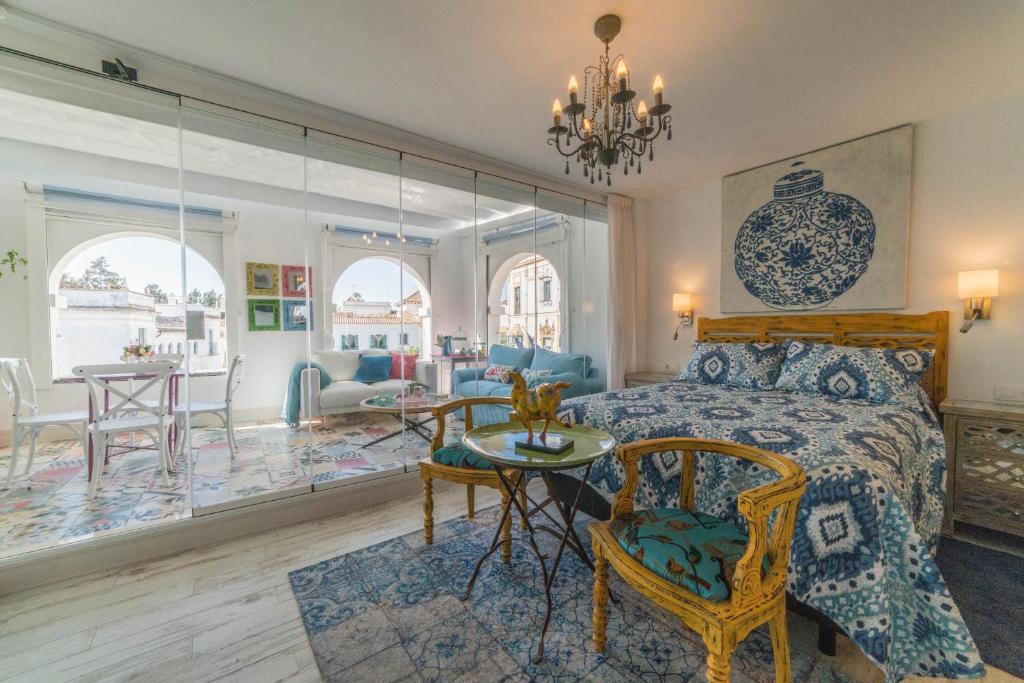 a bedroom with a bed and a table and chairs at Rey Don Pedro Luxury Home in Seville