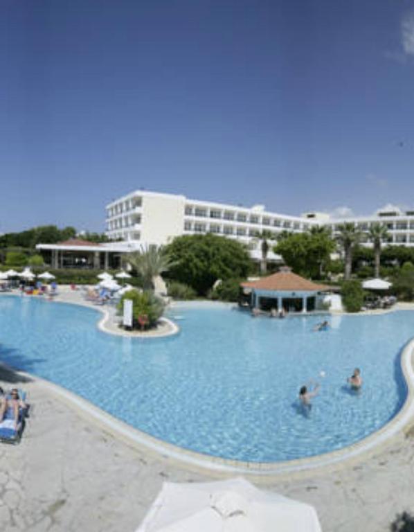 una grande piscina con persone in acqua di Avanti Hotel a Paphos