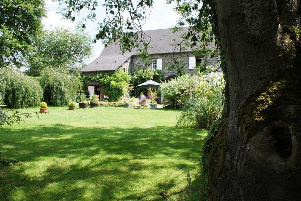 una casa con un patio verde con un gran césped en Les Rivieres, en Caumont-sur-Orne