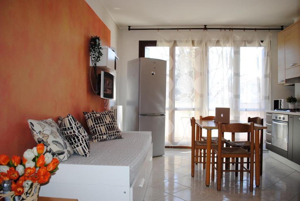 uma cozinha com um frigorífico, uma mesa e cadeiras em Bnbook Bilo Malpensa em Gallarate