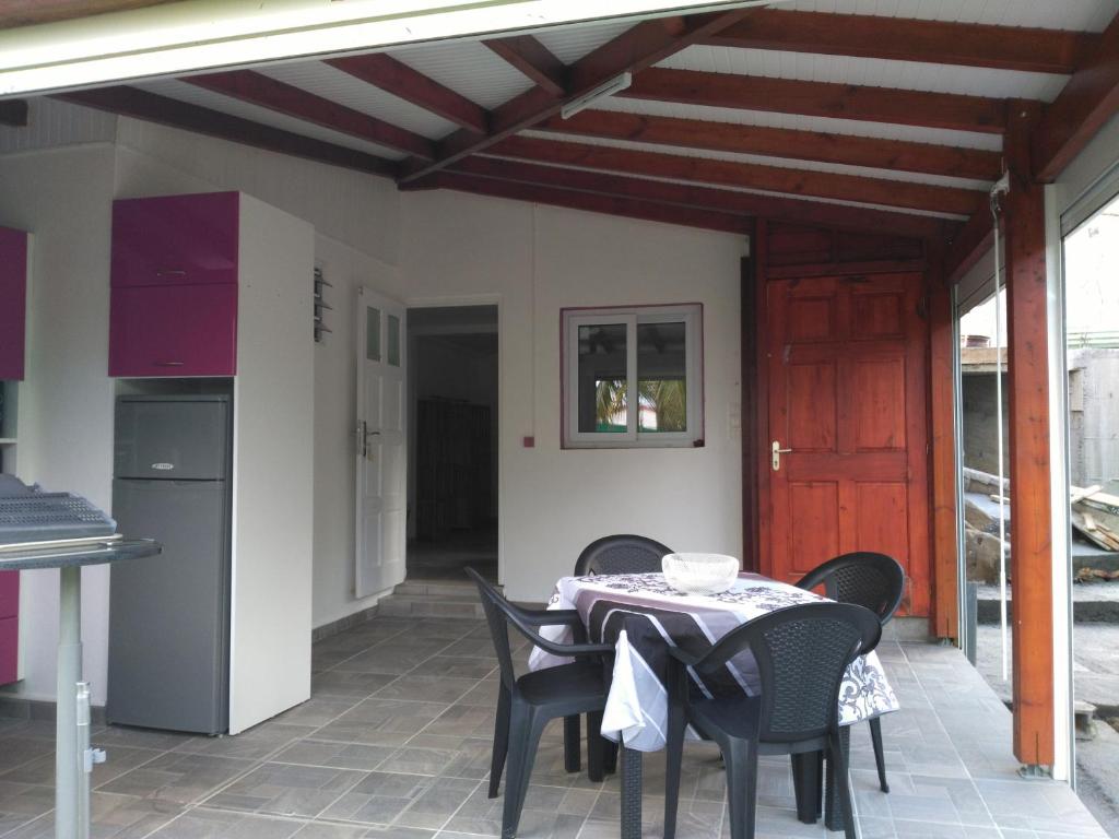 a patio with a table and chairs and a kitchen at Ti Coco in Trois-Rivières