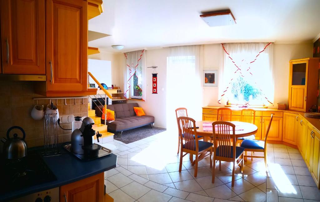 cocina con mesa, sillas y sofá en Aurora Premium Home, en Győr