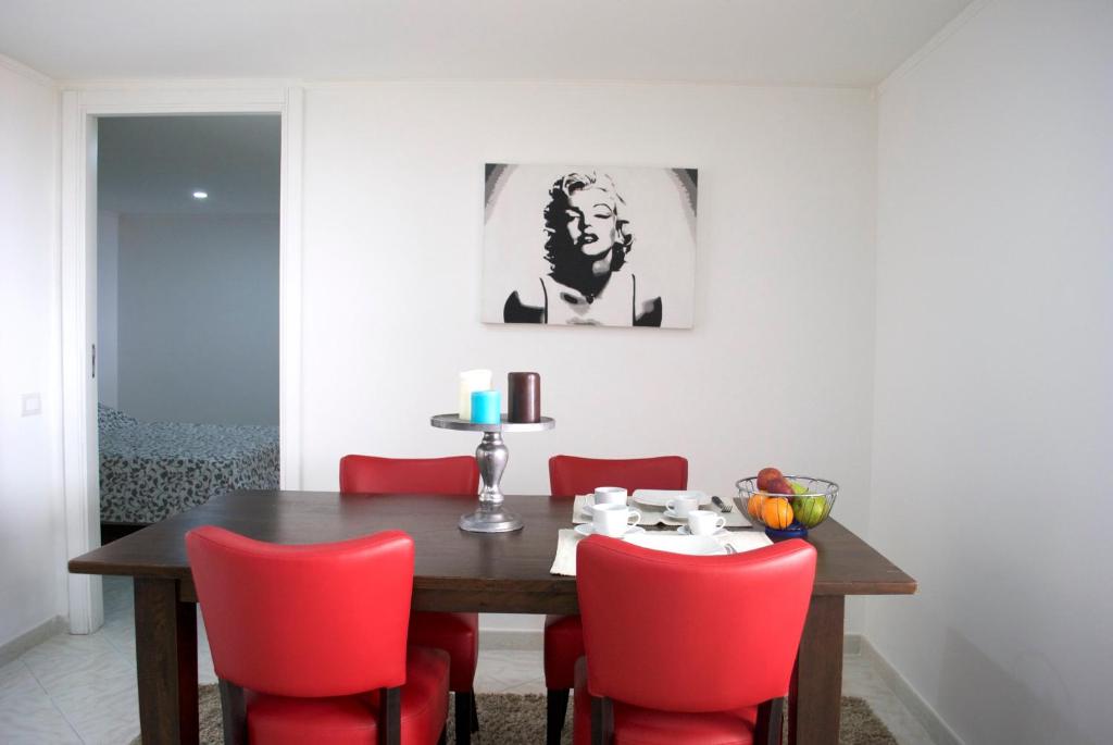 een eetkamer met een houten tafel en rode stoelen bij La Casetta Rossa in Napels