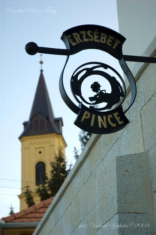 a sign hanging on the side of a brick wall at Erzsébet Pince in Tokaj