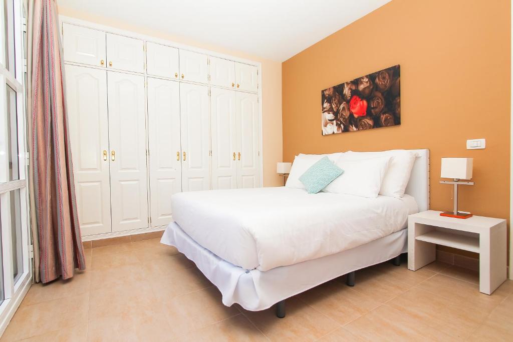 - une chambre avec un grand lit blanc dans l'établissement Coral Los Silos - Your Natural Accommodation Choice, à Los Silos