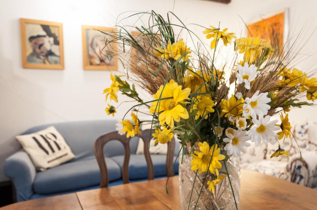 パレルモにあるCasetta Nostraのテーブルの上に黄白花を咲かせた花瓶