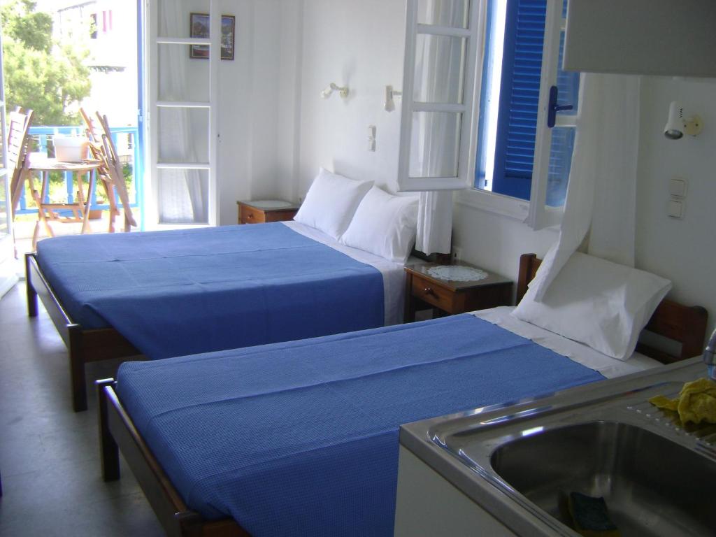 Habitación de hotel con 2 camas y lavamanos en La Fontana en Naxos