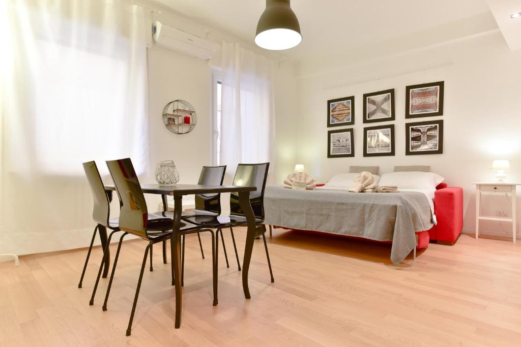 1 dormitorio con mesa, sillas y 1 cama en iFlat Via Veneto Design Studio en Roma