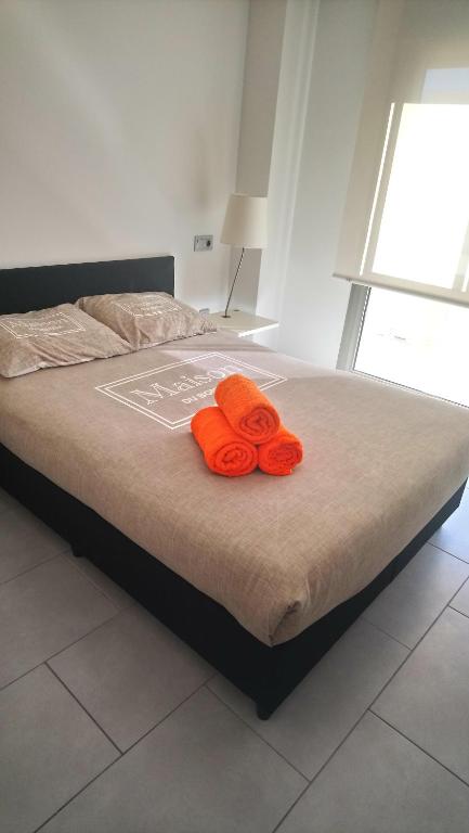 a bed with two orange towels on top of it at Apartamentos Marjal 3 in Guardamar del Segura