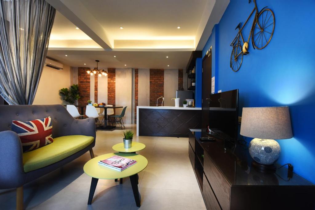 a living room with a blue wall at Backyard Rio Melaka in Melaka