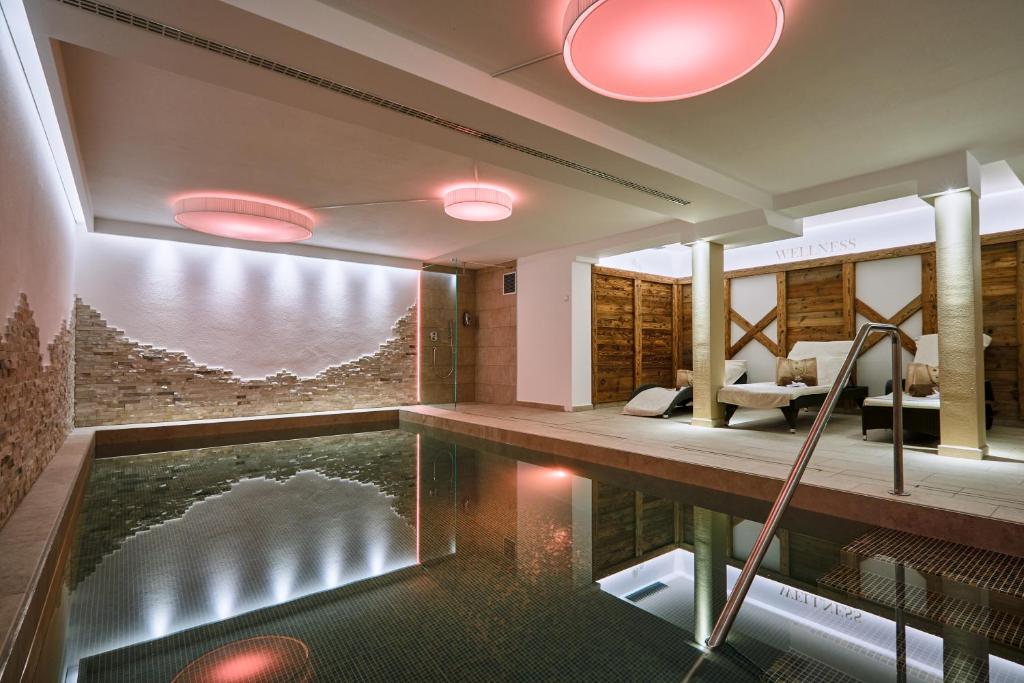 a house with a pool in the middle of a room at Hotel Garnì Savoy in Castelrotto