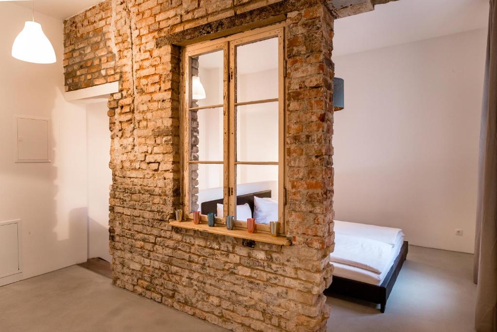 una parete in mattoni con finestra in una camera da letto di Loft in the middle of Berlin a Berlino