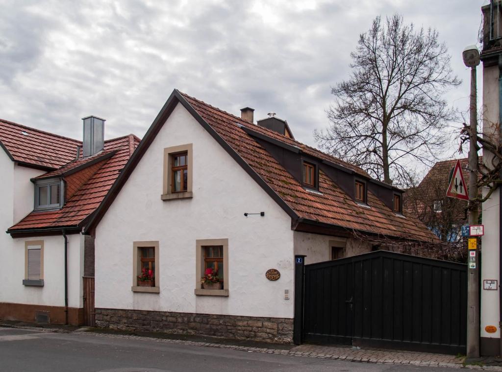 Biały dom z czerwonym dachem w obiekcie Ferienwohnung Kleine Akademie w mieście Schonungen