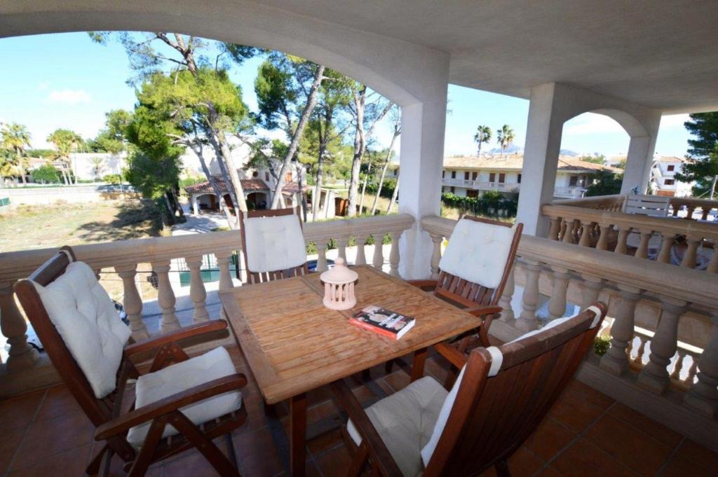 アルクーディアにあるApartamento Cerca De La Playaの木製のテーブルと椅子が置かれたポーチ