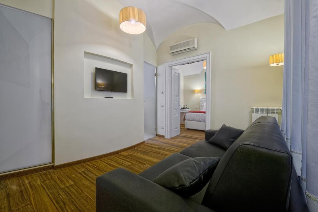 salon z kanapą i telewizorem w obiekcie Star Vatican Rooms w Rzymie