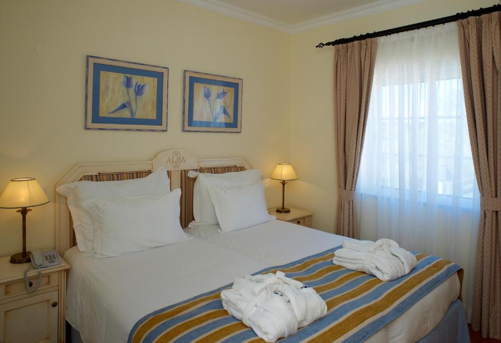 a bedroom with two beds with towels on them at Vila Alba Resort in Carvoeiro