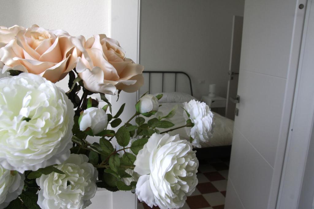 un jarrón lleno de flores blancas en una habitación en Il Capitano en Lerici