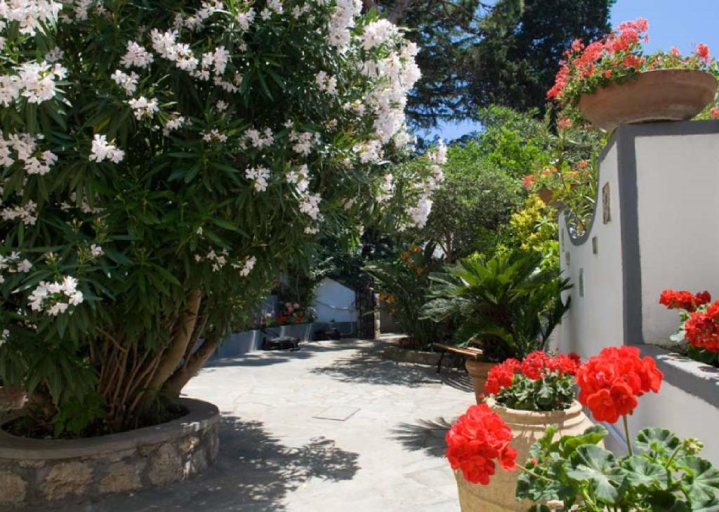 a garden with flowers in pots next to a building at Villa Le Terrazze di Capri in Capri