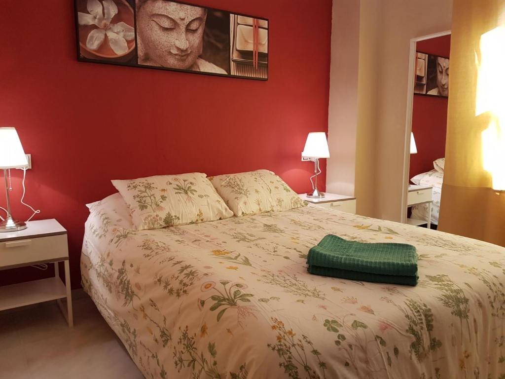 ein Schlafzimmer mit einem Bett mit einem grünen Kissen darauf in der Unterkunft TRIANA RUISEÑOR in Sevilla