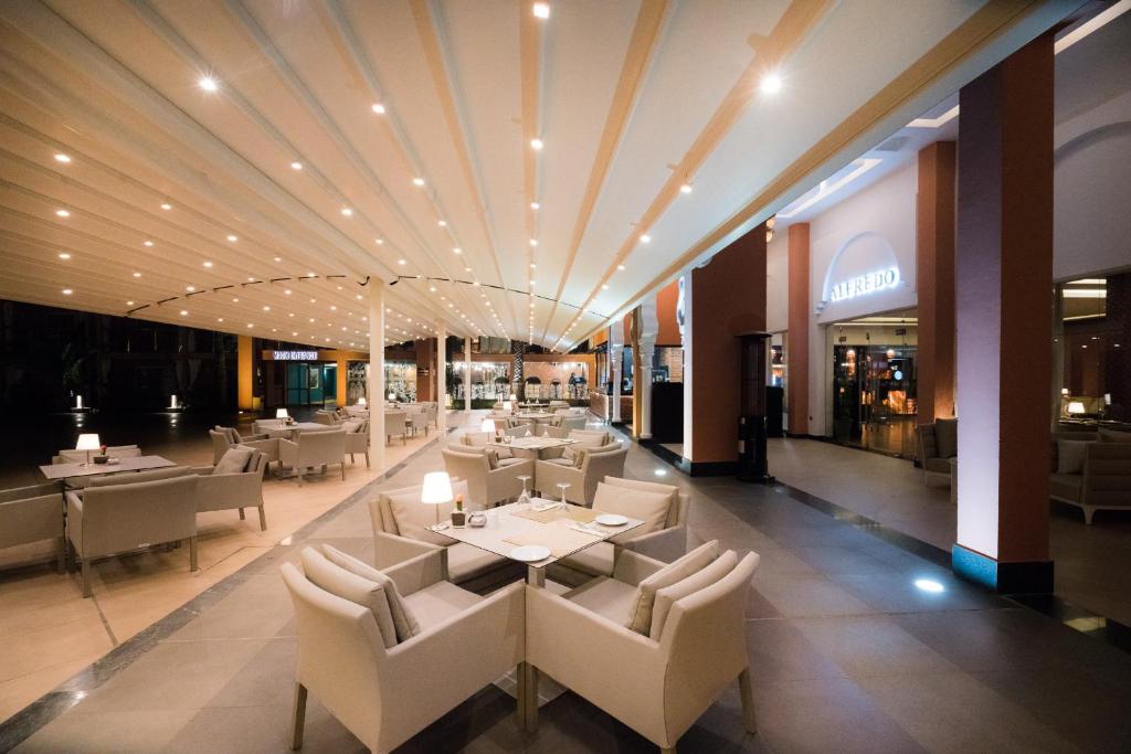 a restaurant with tables and chairs in a building at Savoy Le Grand Hotel Marrakech in Marrakesh
